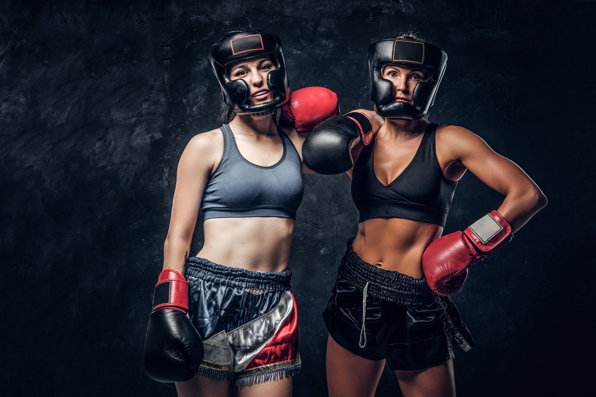 Dos boxeadoras con casco y guantes