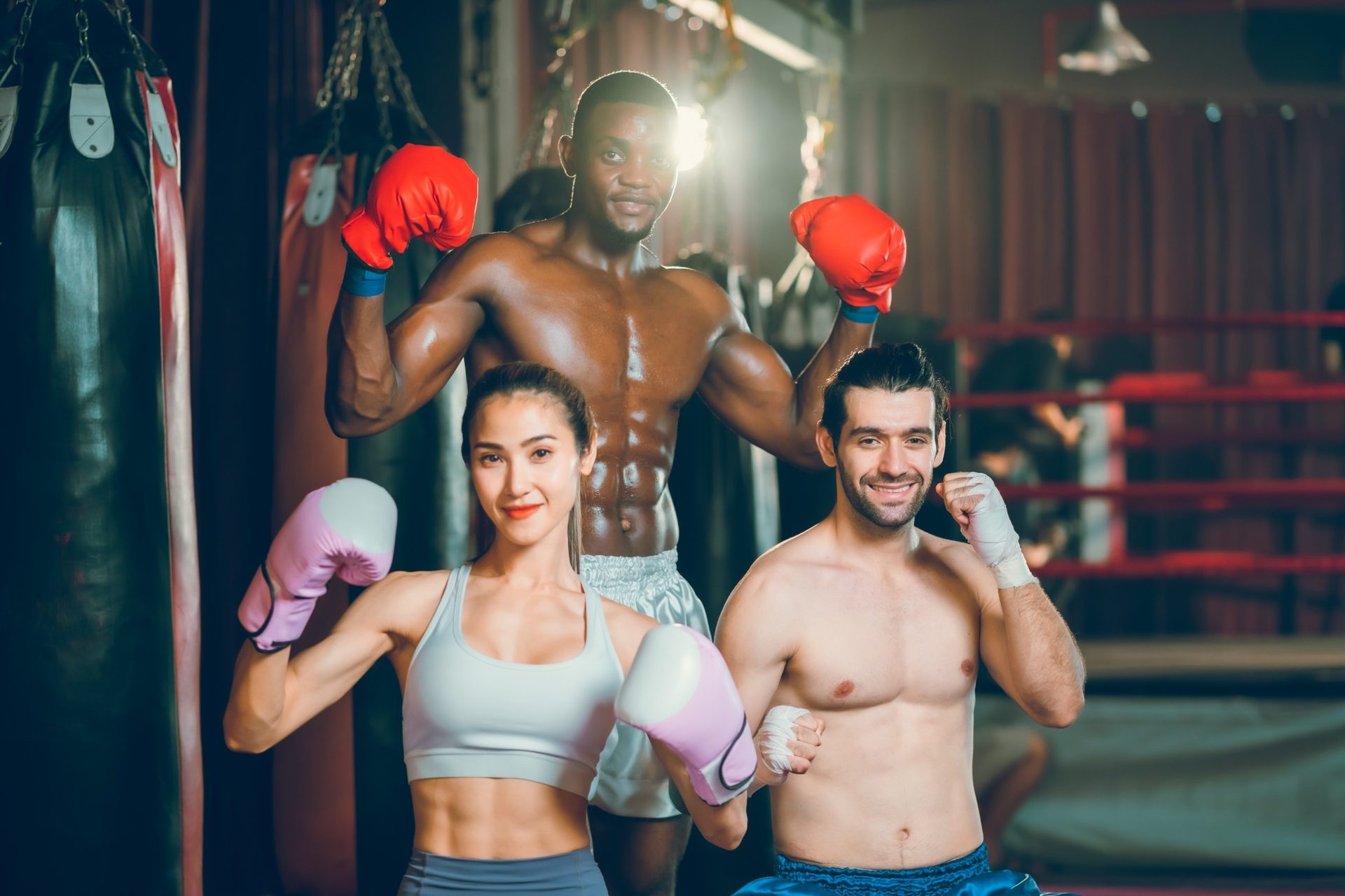 Comunidad ARES: tres deportistas sonriendo con guantes en el gimnasio