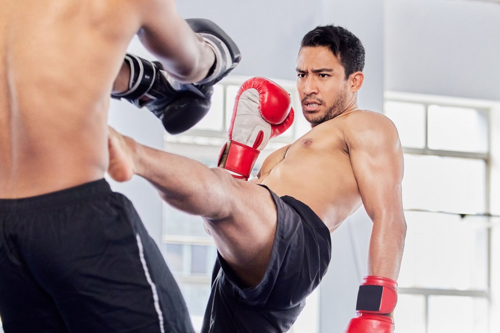 Peleador lanzando una patada durante un entrenamiento de kickboxing